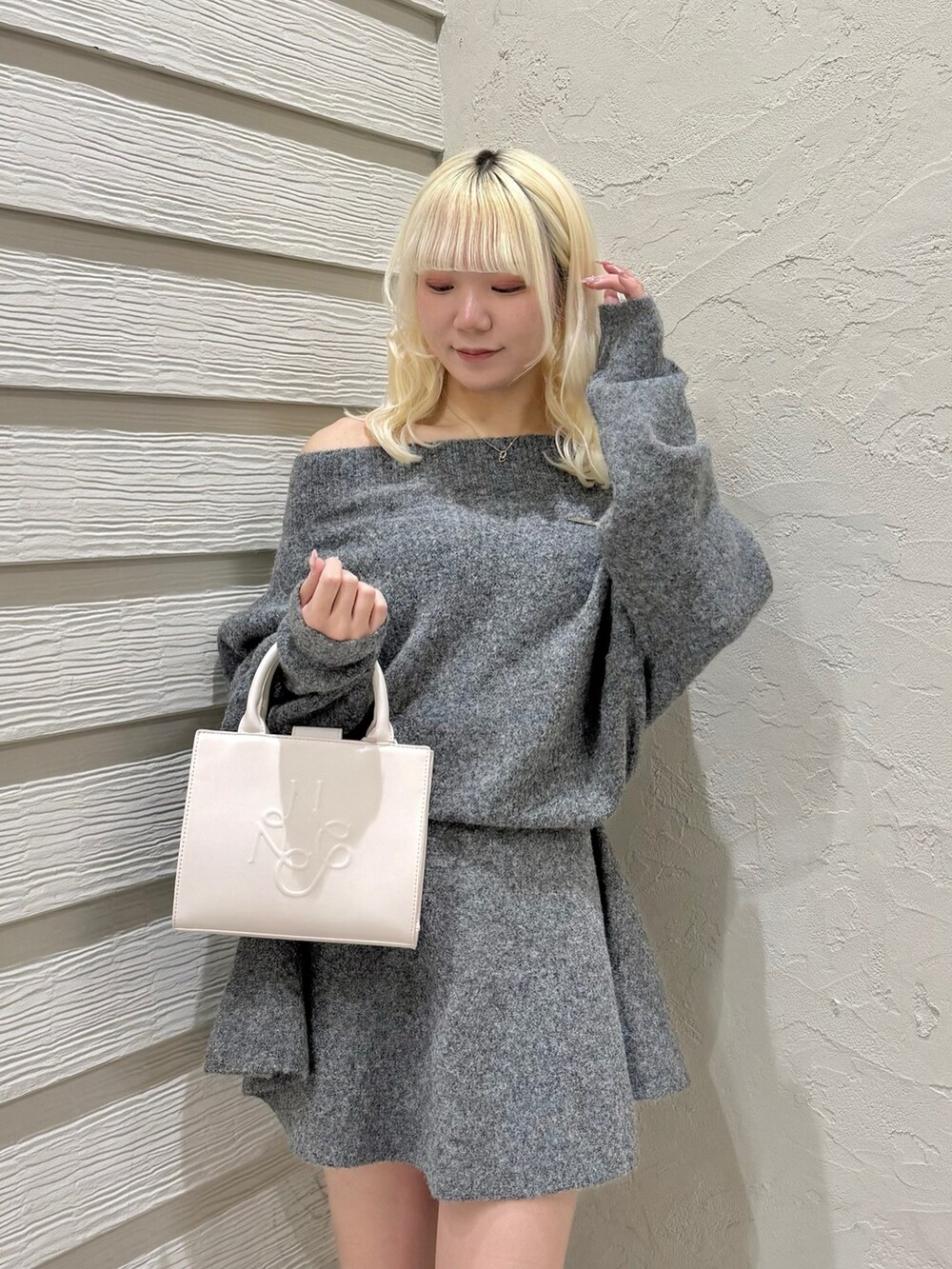 グレー系のセットアップ、ピンク系のトートバッグ、ブラック系のブーツを着用したレディースの冬コーディネートの4枚目の写真