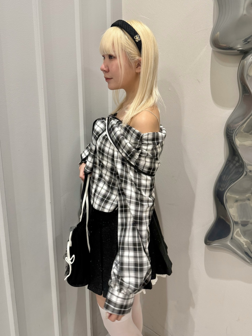 ホワイト系のシャツ/ブラウス、ブラック系のスカート、ブラック系のパンプスを着用したレディースの春コーディネートの5枚目の写真