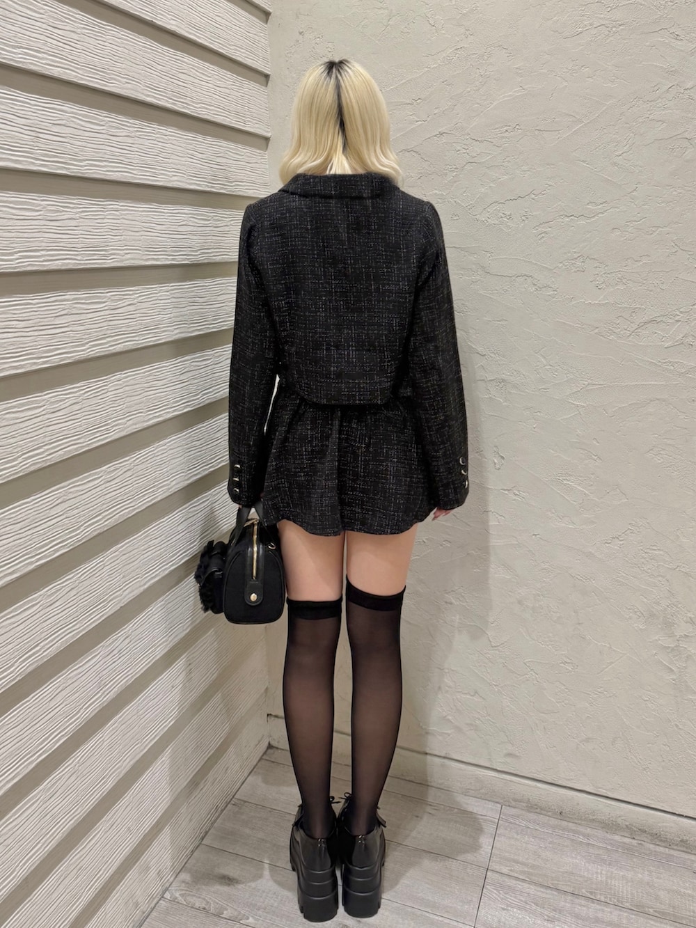 ブラック系のショルダーバッグ、ブラック系のスカート、ブラック系のテーラードジャケットを着用したレディースの冬コーディネートの3枚目の写真