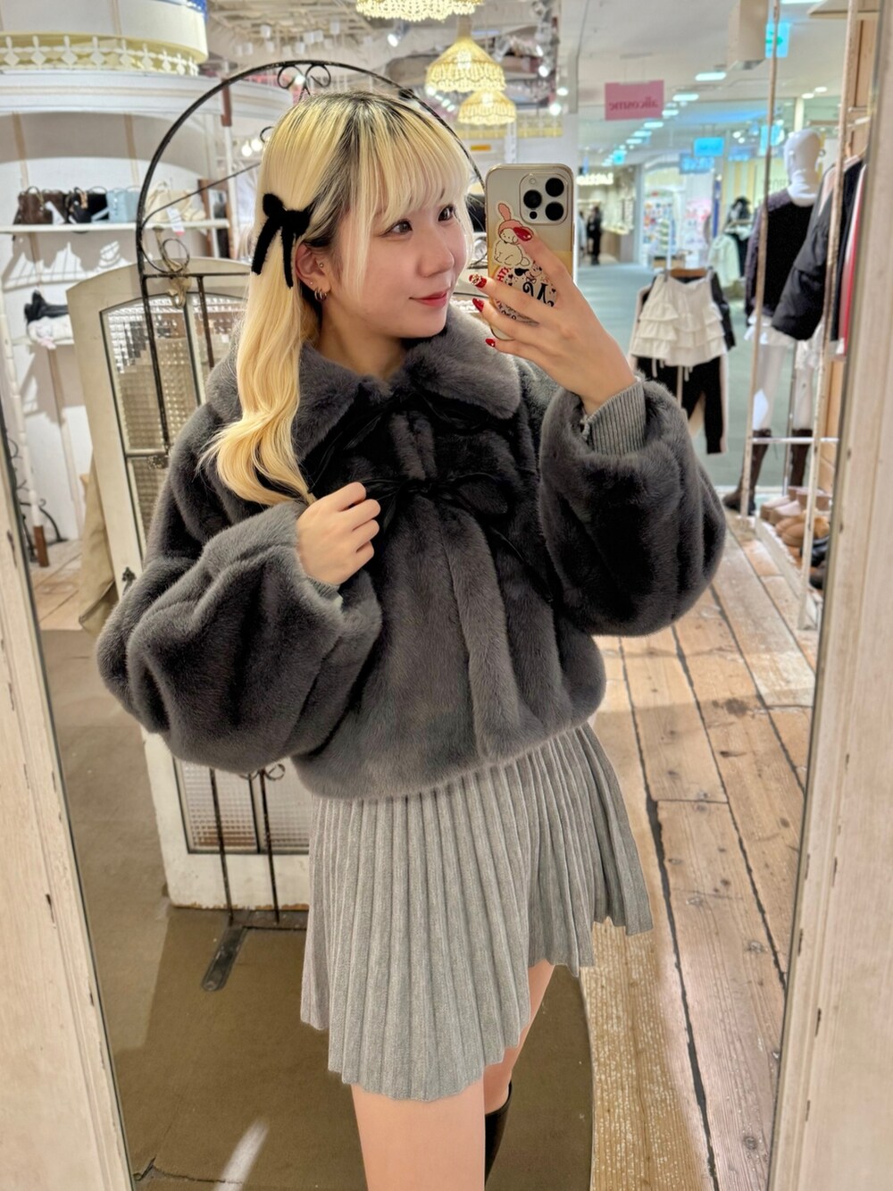 ホワイト系のトートバッグ、グレー系のスカート、グレー系のブルゾンを着用したレディースの冬コーディネートの2枚目の写真