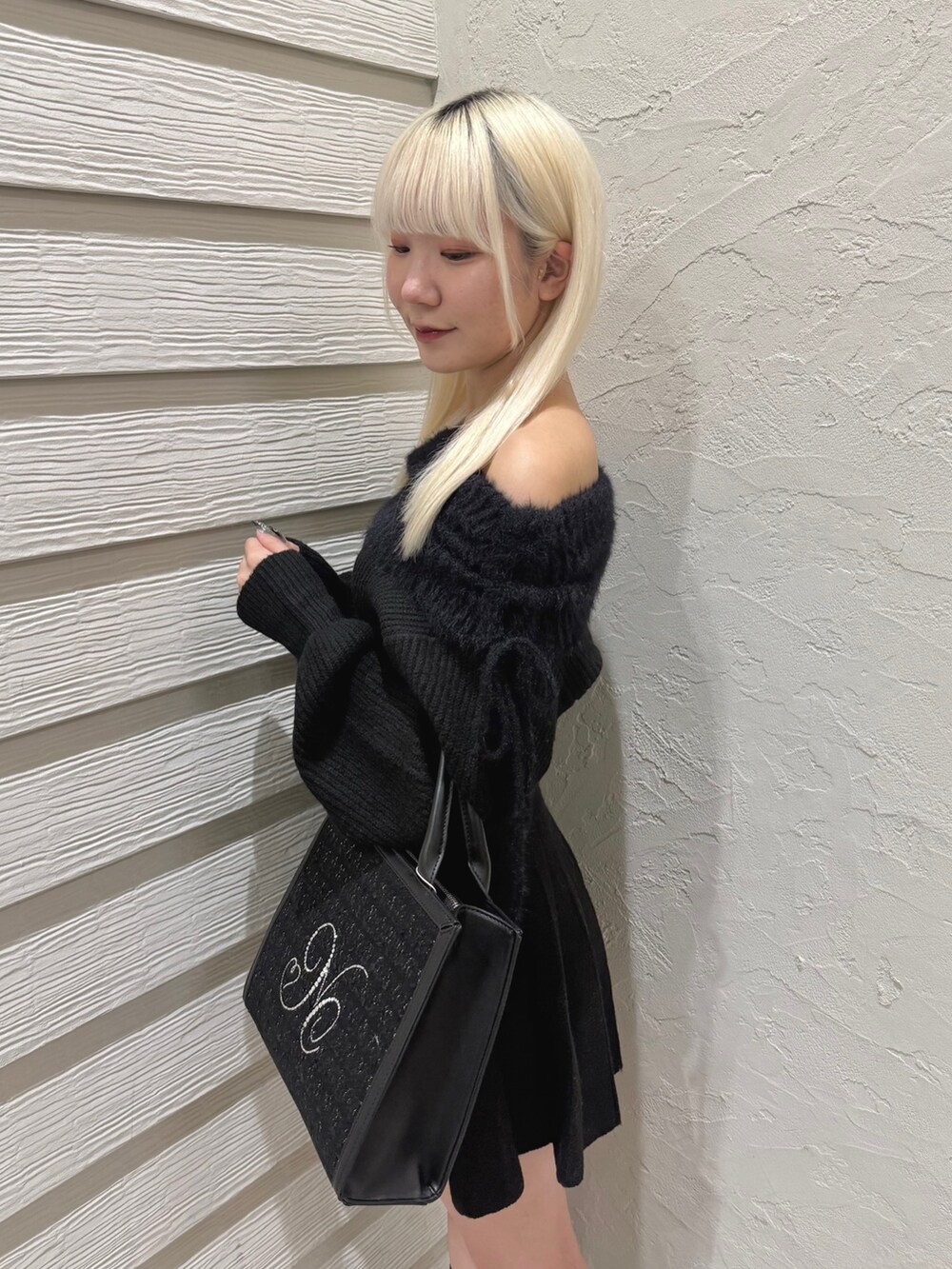 ブラック系のワンピース、ブラック系のトートバッグ、ブラック系のブーツを着用したレディースの秋コーディネートの5枚目の写真