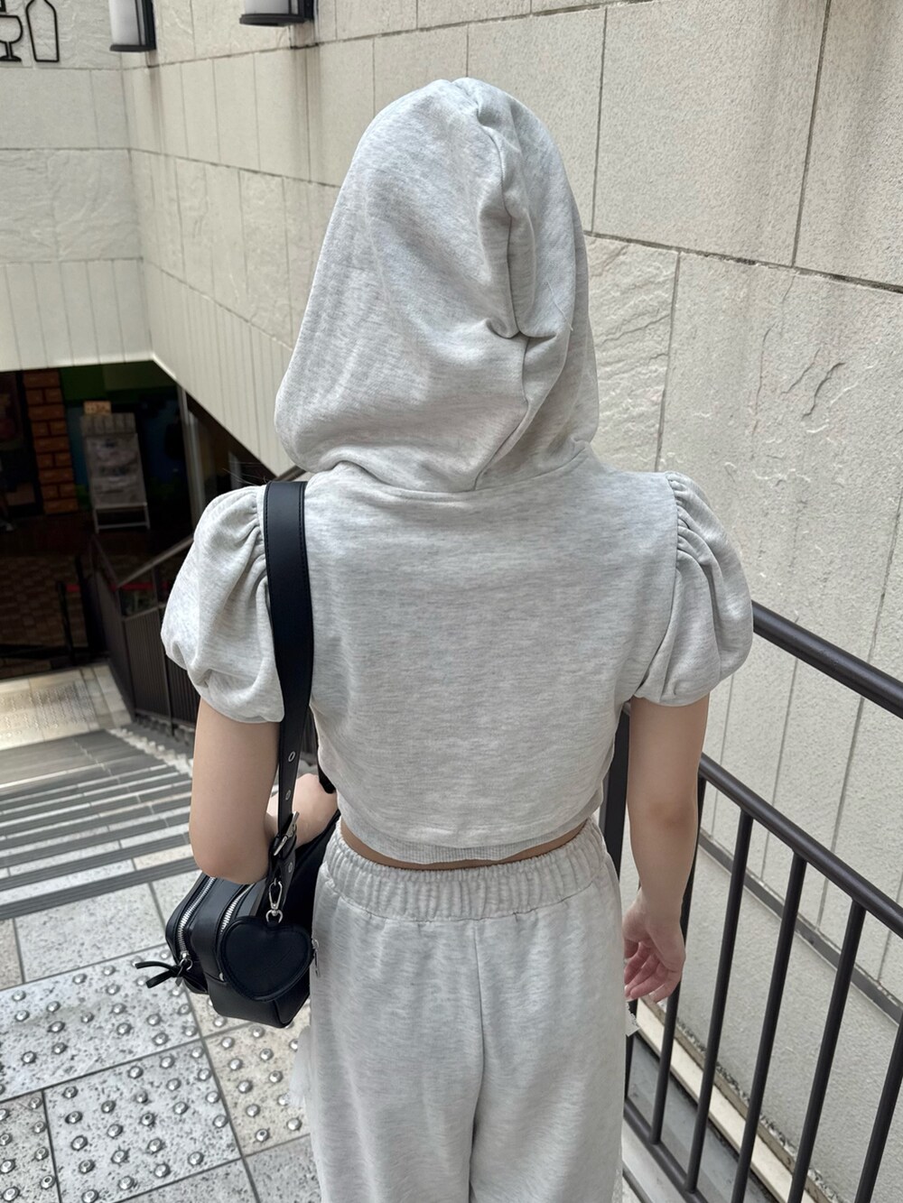 ベージュ系のTシャツ/カットソー、ベージュ系のスウェットパンツ、ブラック系のショルダーバッグを着用したレディースの夏コーディネートの6枚目の写真