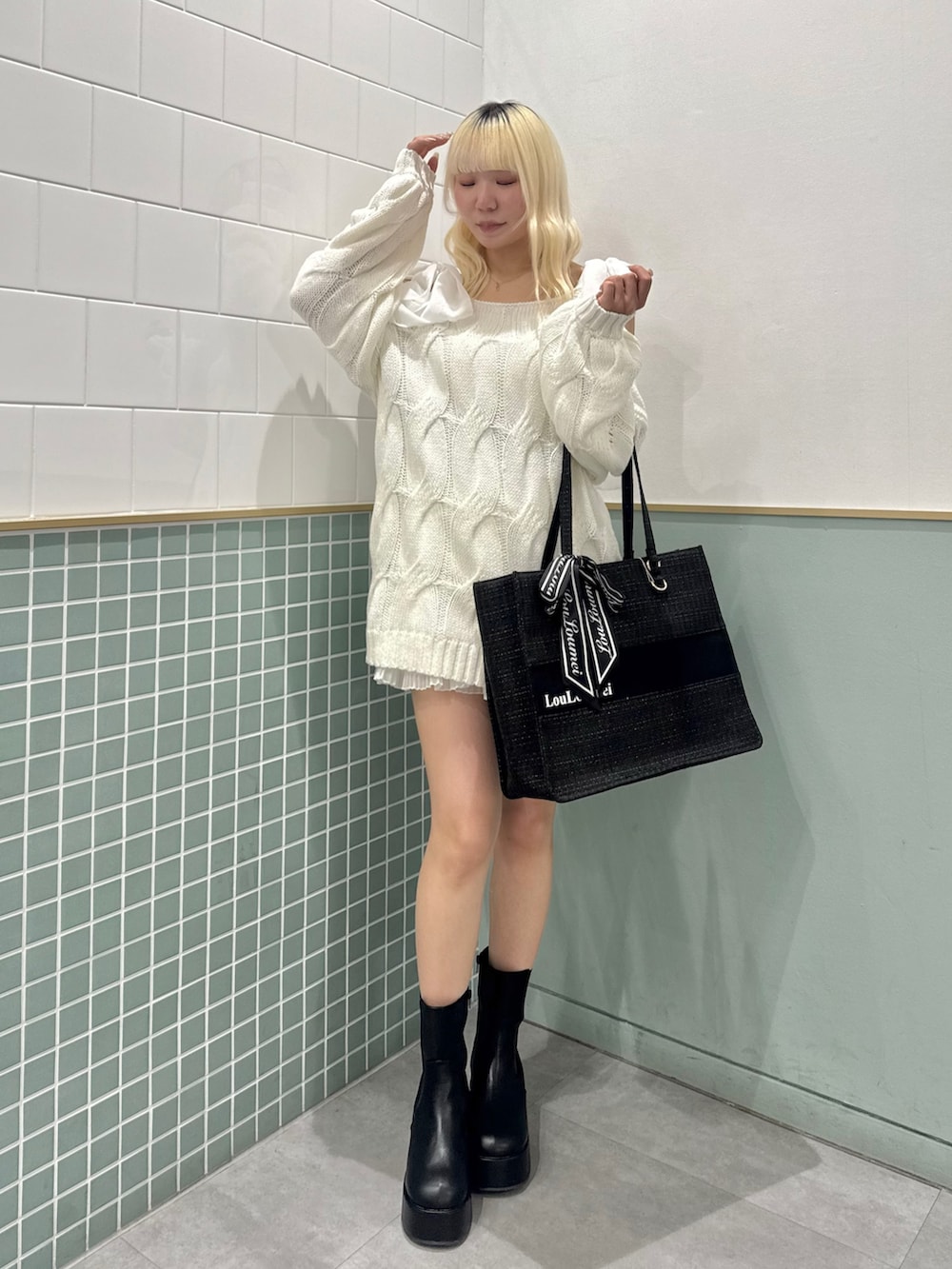 ブラック系のトートバッグ、ブラック系のブーツ、ホワイト系のワンピースを着用したレディースの冬コーディネートの4枚目の写真