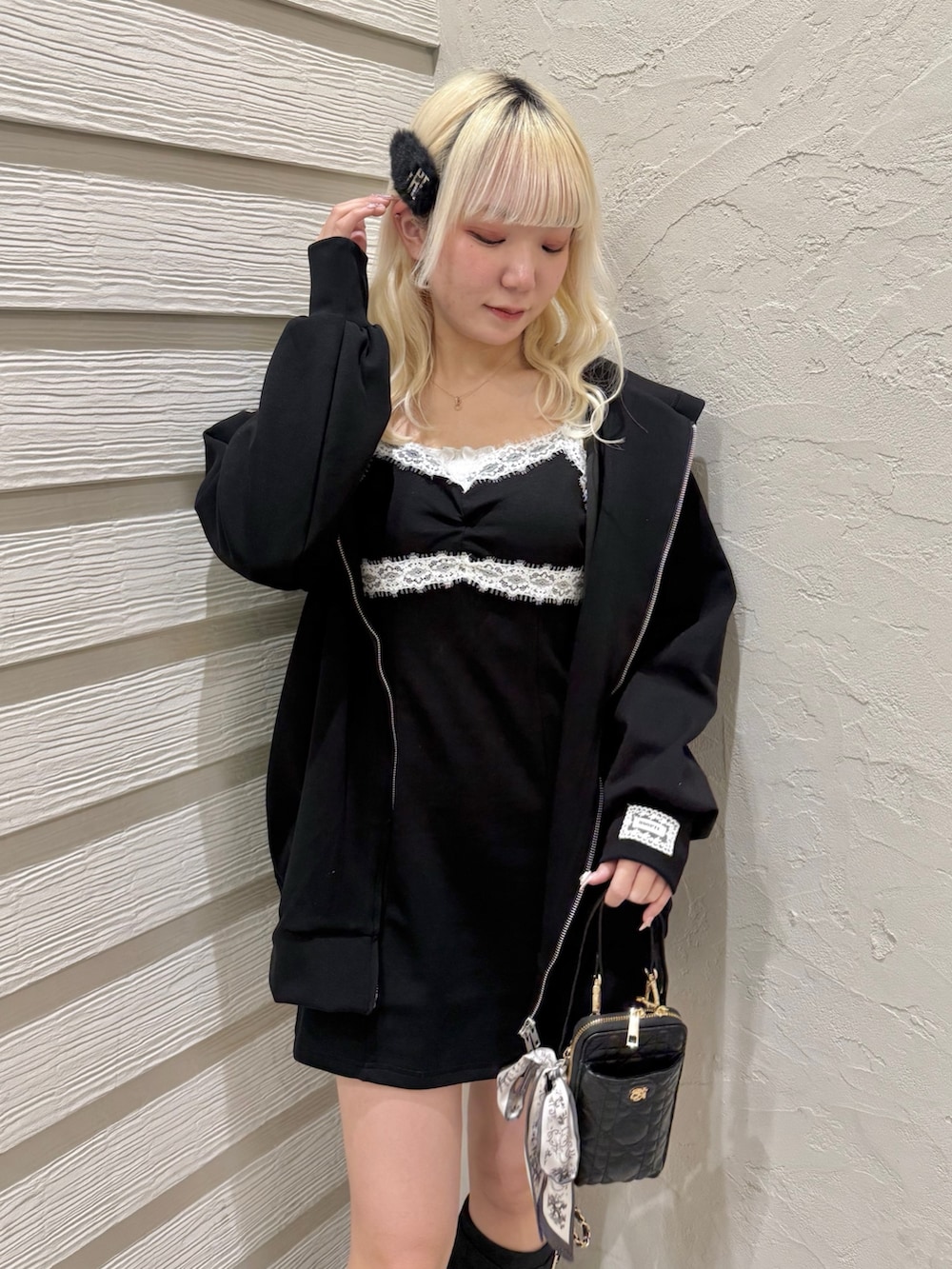 ブラック系のワンピース、ブラック系のパーカー、ブラック系のショルダーバッグを着用したレディースの冬コーディネートの4枚目の写真