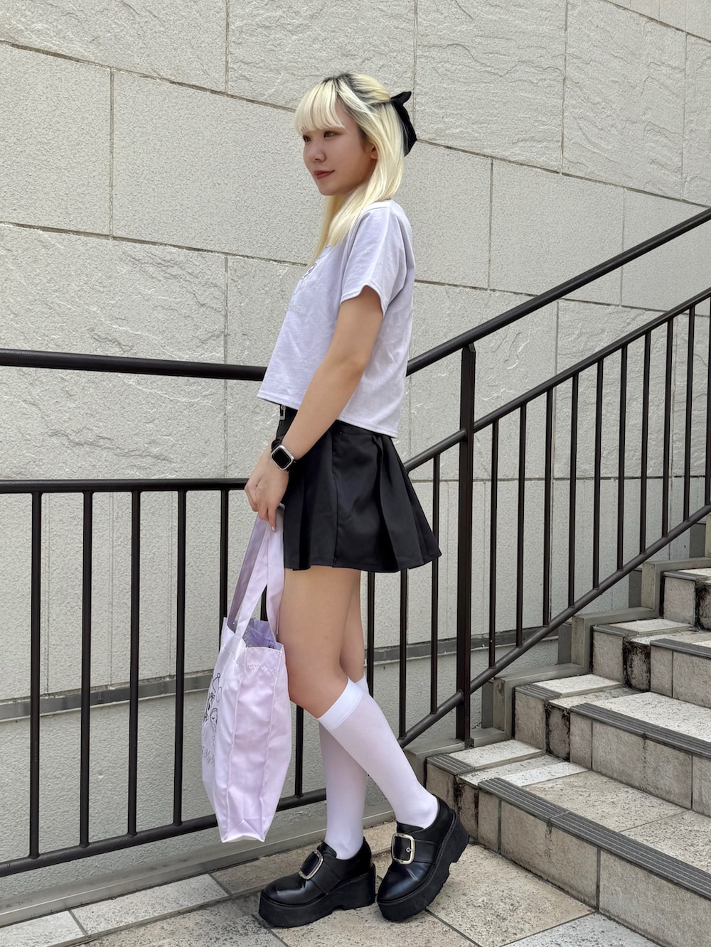 パープル系のトートバッグ、パープル系のTシャツ/カットソー、ブラック系のスカートを着用したレディースの夏コーディネートの3枚目の写真