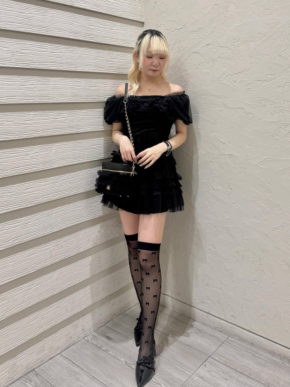 ブラック系のワンピース、ブラック系のショルダーバッグ、ブラック系のパンプスを着用したレディースの春コーディネートの2枚目の写真
