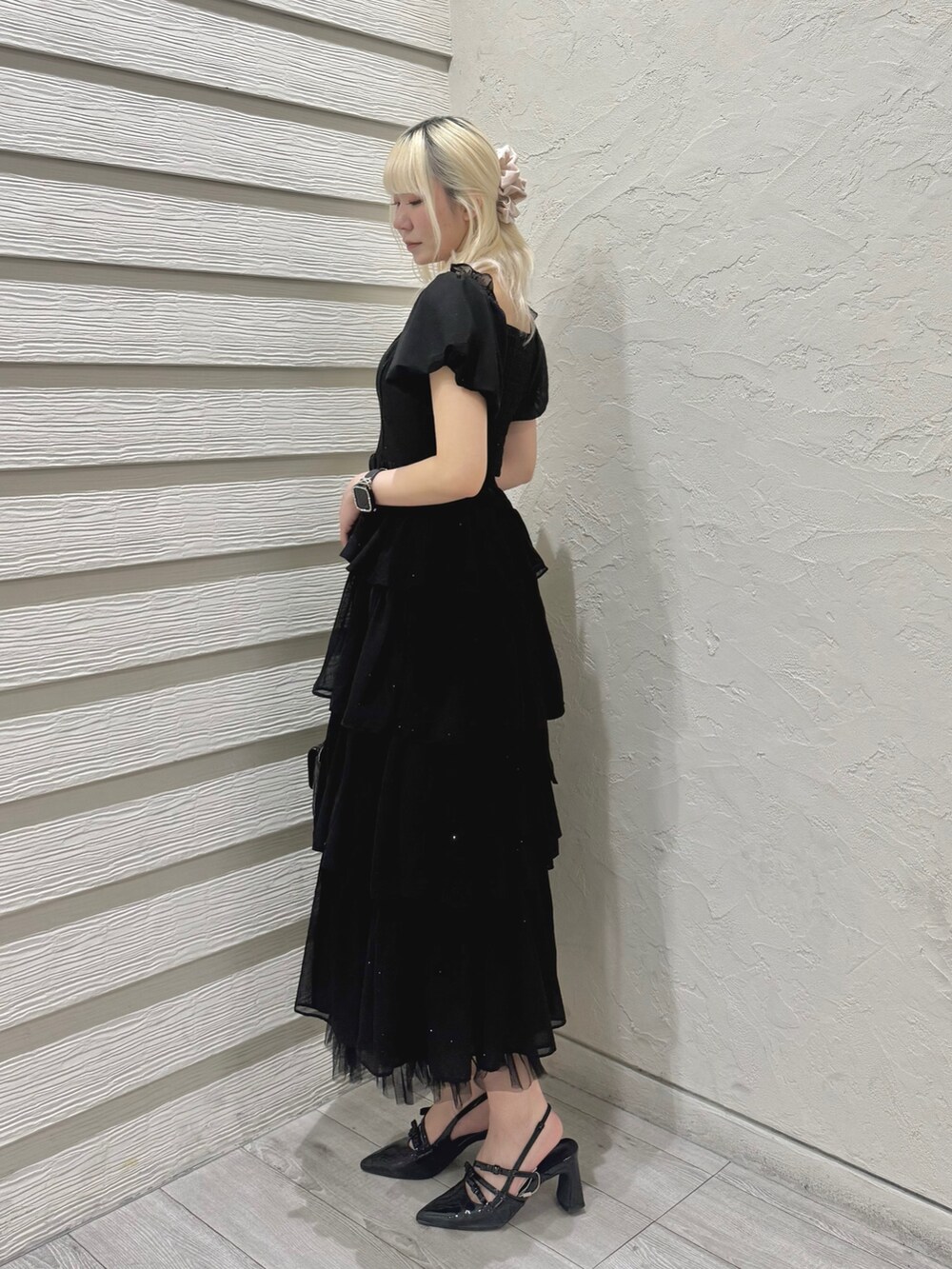 ブラック系のワンピース、ブラック系のショルダーバッグ、ブラック系のパンプスを着用したレディースの春コーディネートの3枚目の写真