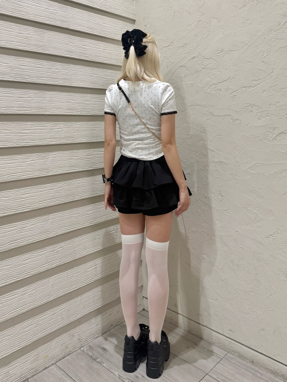 ブラック系のスカート、ブラック系のショルダーバッグ、その他のTシャツ/カットソーを着用したレディースの夏コーディネートの3枚目の写真
