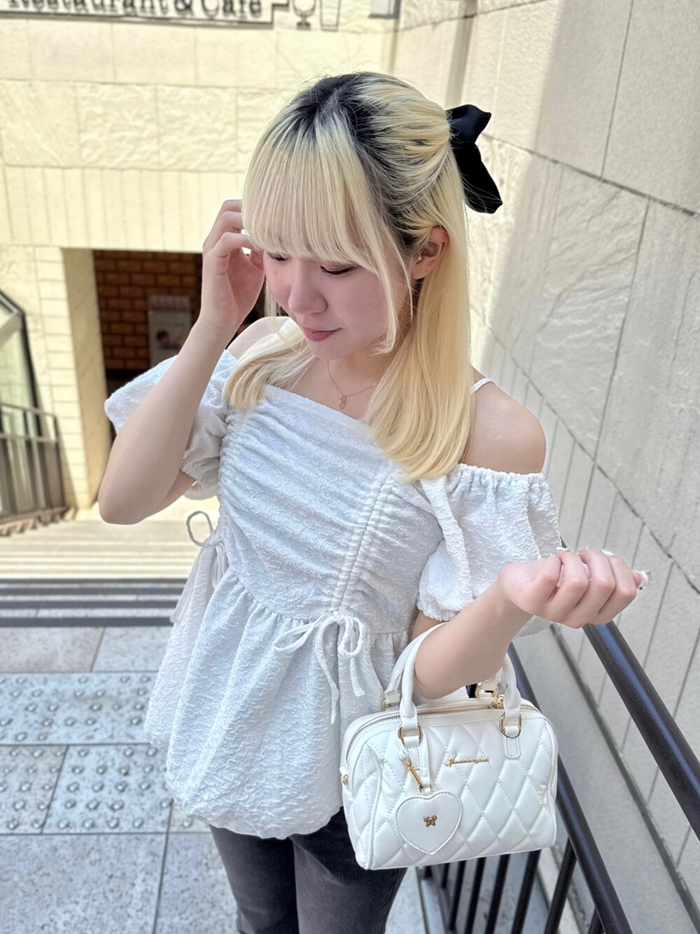 ホワイト系のシャツ/ブラウス、ブラック系のデニムパンツ、ホワイト系のボストンバッグを着用したレディースの夏コーディネートの3枚目の写真