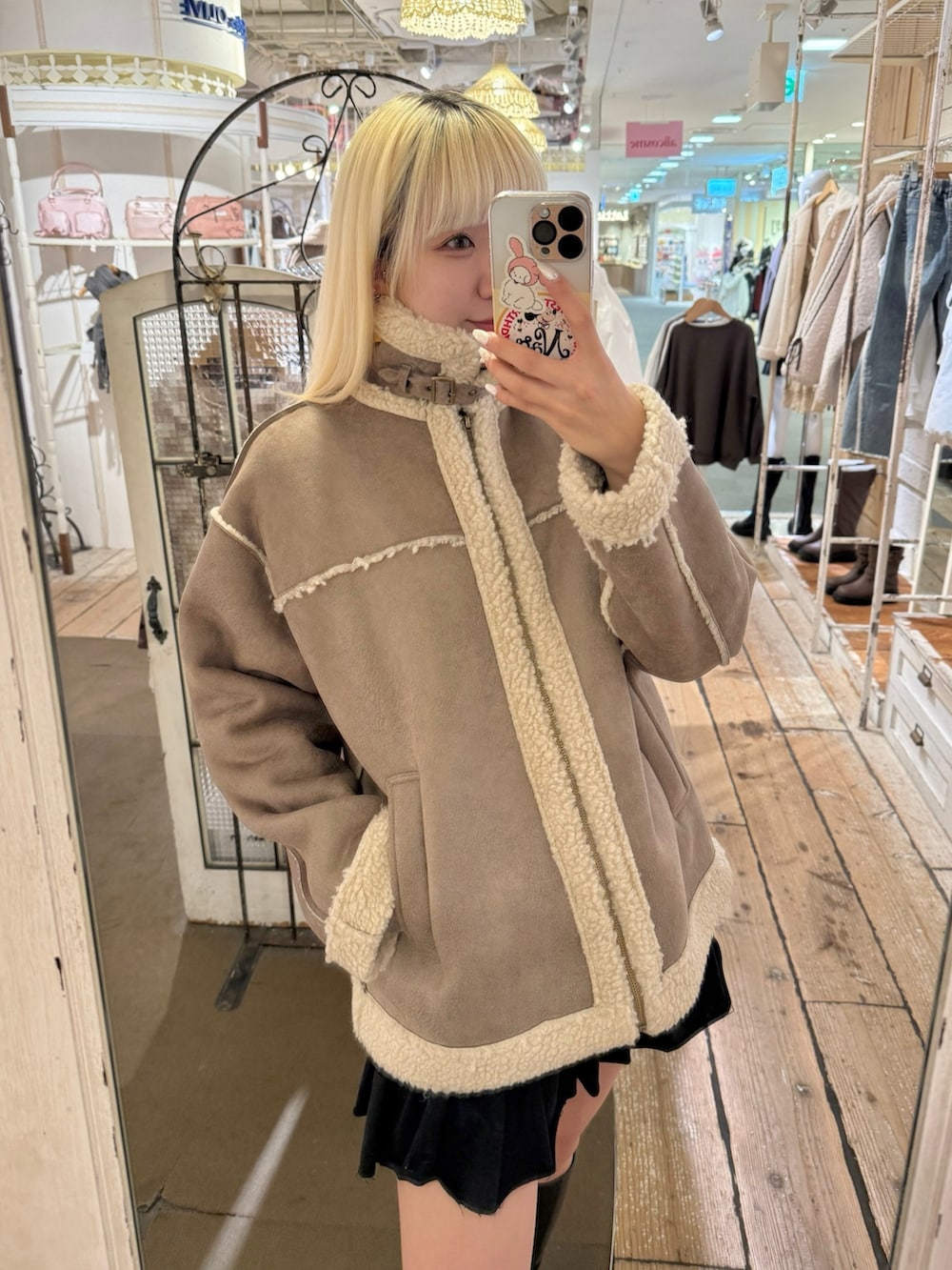 ブラウン系のブルゾン、ブラック系のスカートを着用したレディースの秋コーディネートの3枚目の写真