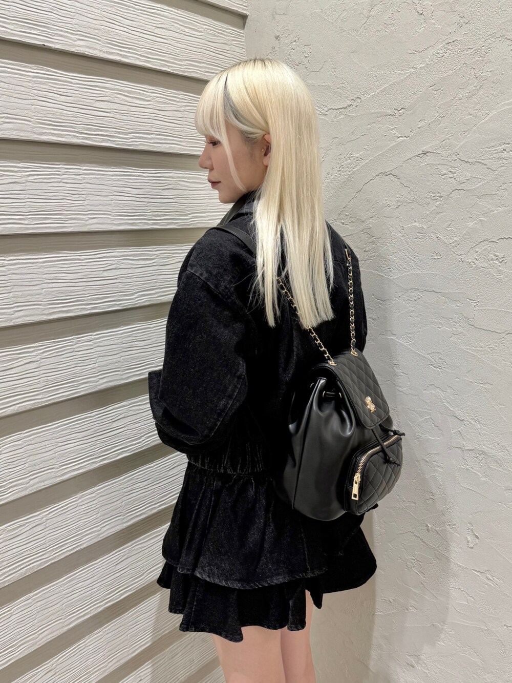 ブラック系のバックパック/リュック、ホワイト系のキャミソール、ブラック系のスカートを着用したレディースの秋コーディネートの5枚目の写真