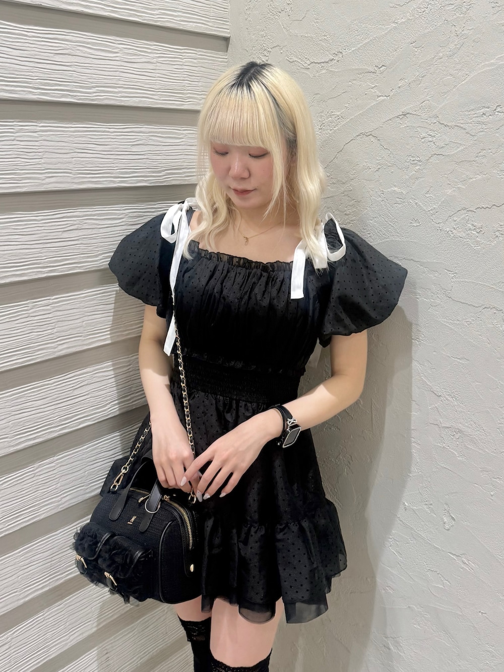 ブラック系のショルダーバッグ、ブラック系のパンプス、ブラック系のワンピースを着用したレディースの春コーディネートの5枚目の写真