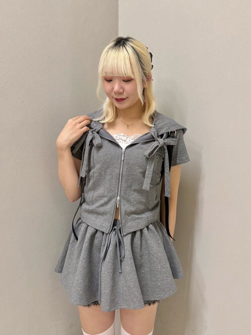 ブラック系のスニーカー、グレー系のスカート、グレー系のパーカーを着用したレディースの夏コーディネートの4枚目の写真