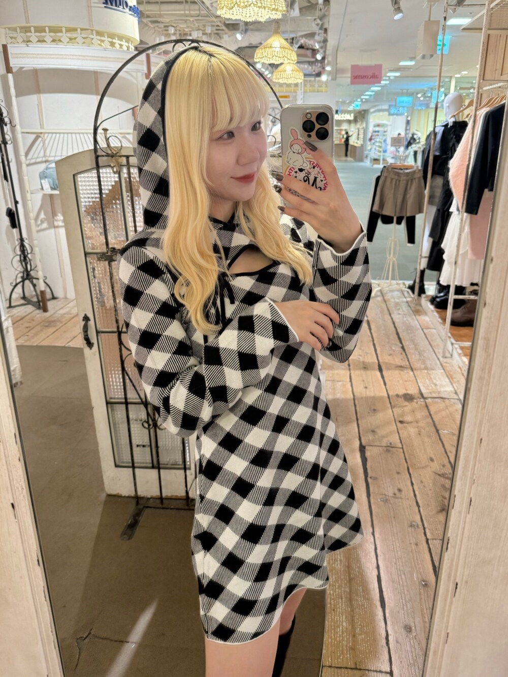 ブラック系のワンピース、ホワイト系のショルダーバッグ、ブラック系のブーツを着用したレディースの秋コーディネートの4枚目の写真