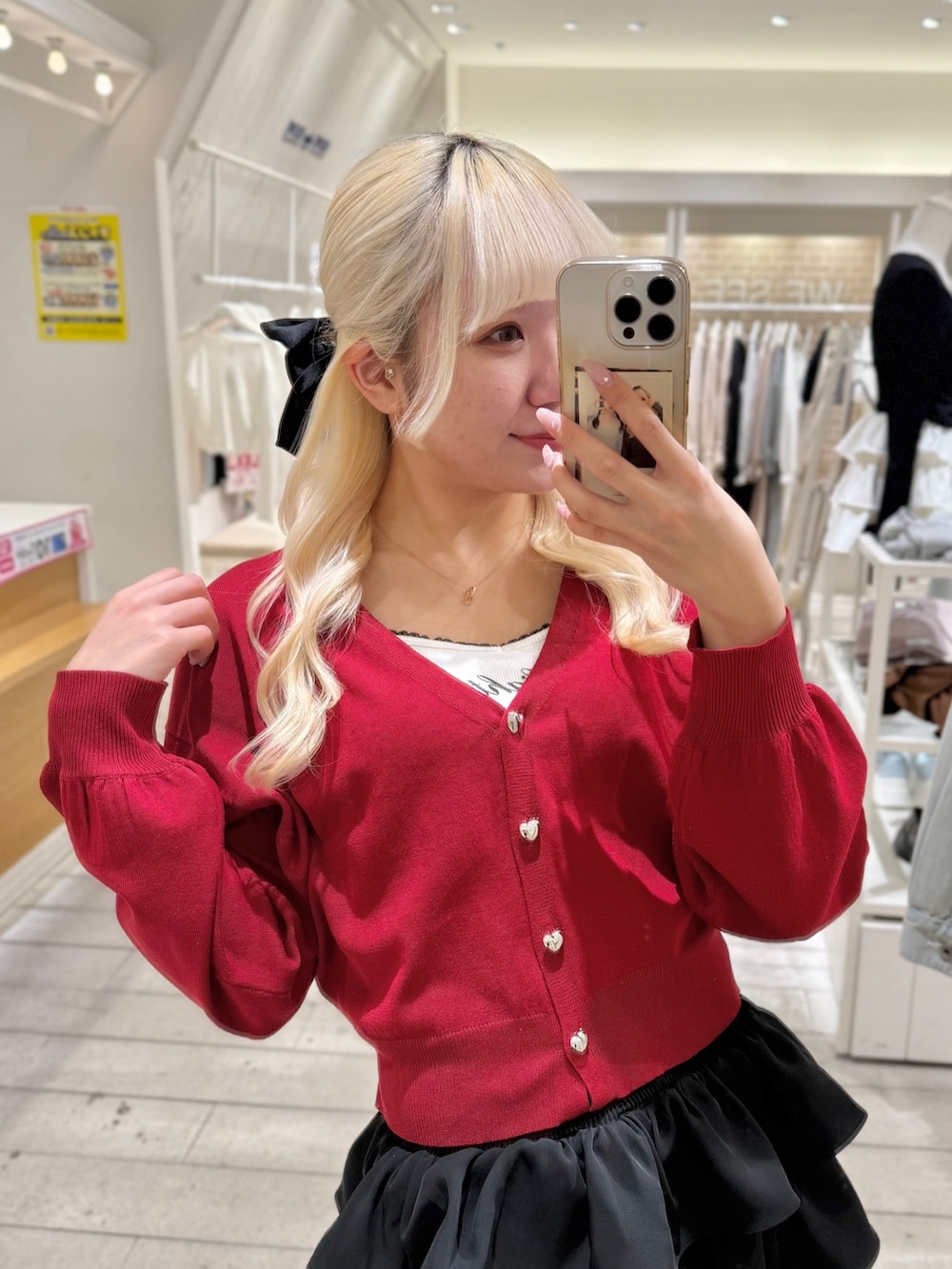 ブラック系のスカート、レッド系のカーディガン/ボレロ、ホワイト系のキャミソールを着用したレディースの春コーディネートの3枚目の写真