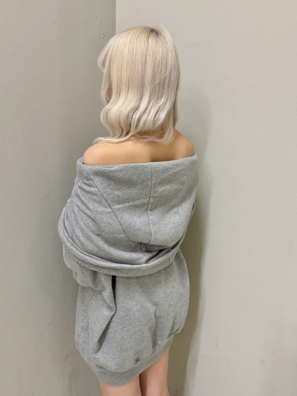 グレー系のパーカー、ブラック系のショルダーバッグ、ブラック系のスニーカーを着用したレディースの春コーディネートの6枚目の写真