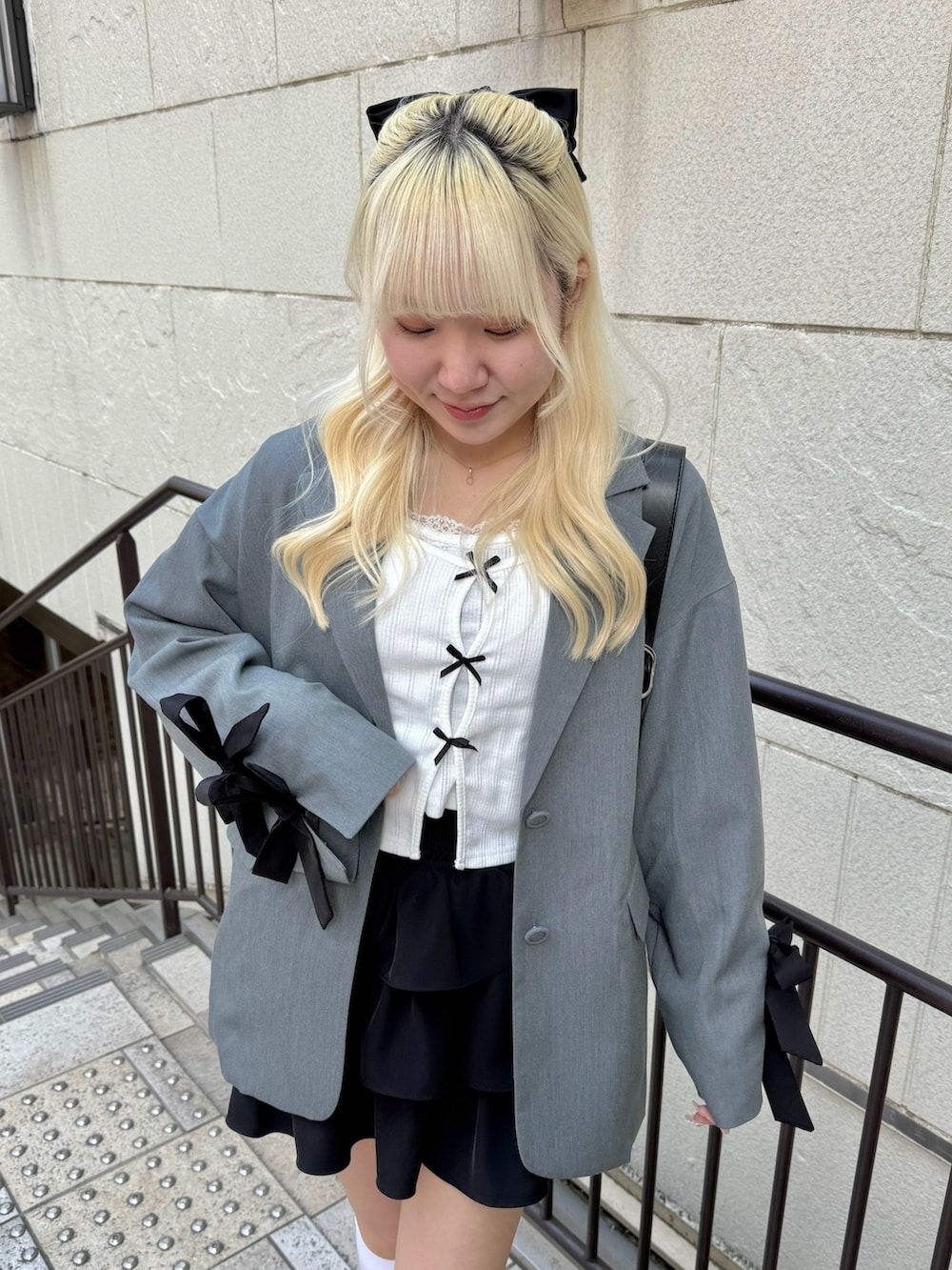 ブラック系のスカート、グレー系のその他アウター、ホワイト系のTシャツ/カットソーを着用したレディースの春コーディネートの4枚目の写真