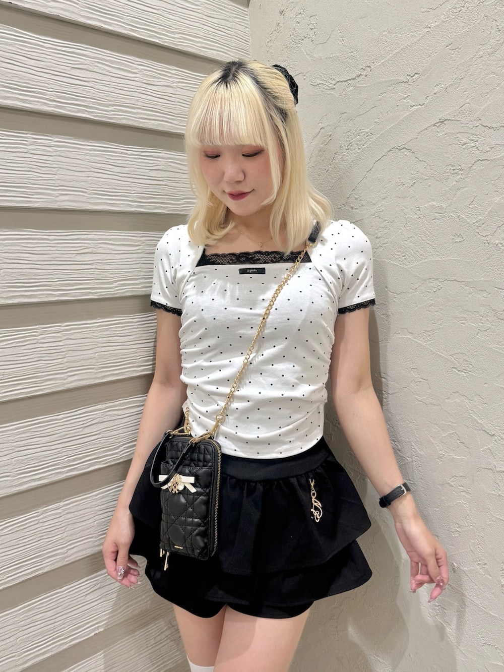 ブラック系のスカート、ブラック系のショルダーバッグ、その他のTシャツ/カットソーを着用したレディースの夏コーディネートの4枚目の写真