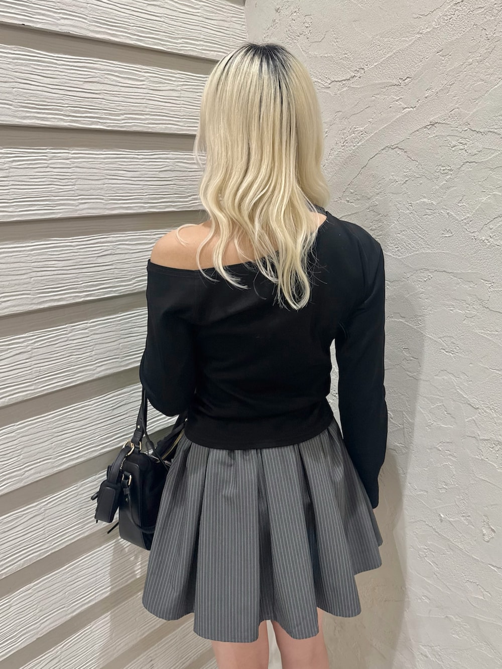 ブラック系のショルダーバッグ、グレー系のスカート、ブラック系のTシャツ/カットソーを着用したレディースの冬コーディネートの6枚目の写真