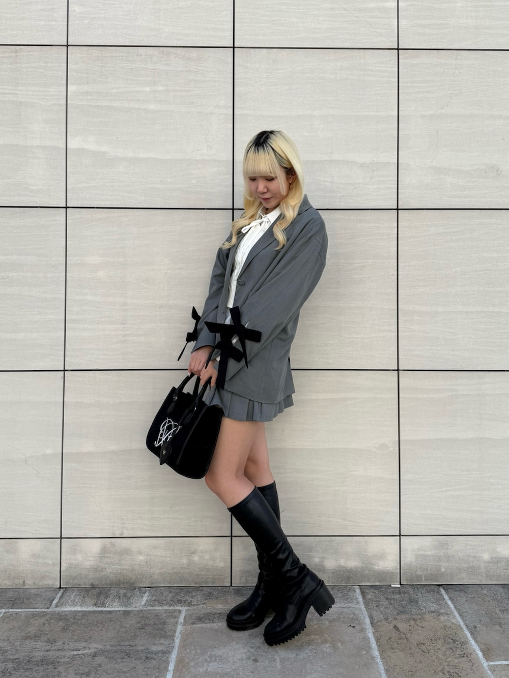 ブラック系のトートバッグ、ホワイト系のシャツ/ブラウス、グレー系のその他アウターを着用したレディースの春コーディネートの2枚目の写真