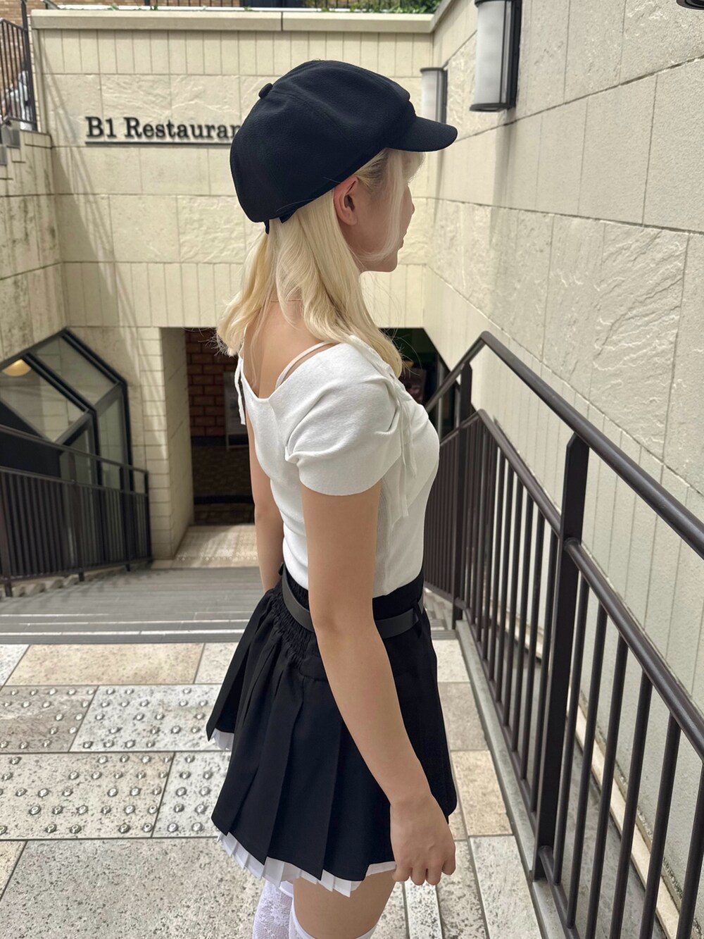 ブラック系のスカート、ホワイト系のTシャツ/カットソー、ブラック系のショルダーバッグを着用したレディースの春コーディネートの5枚目の写真