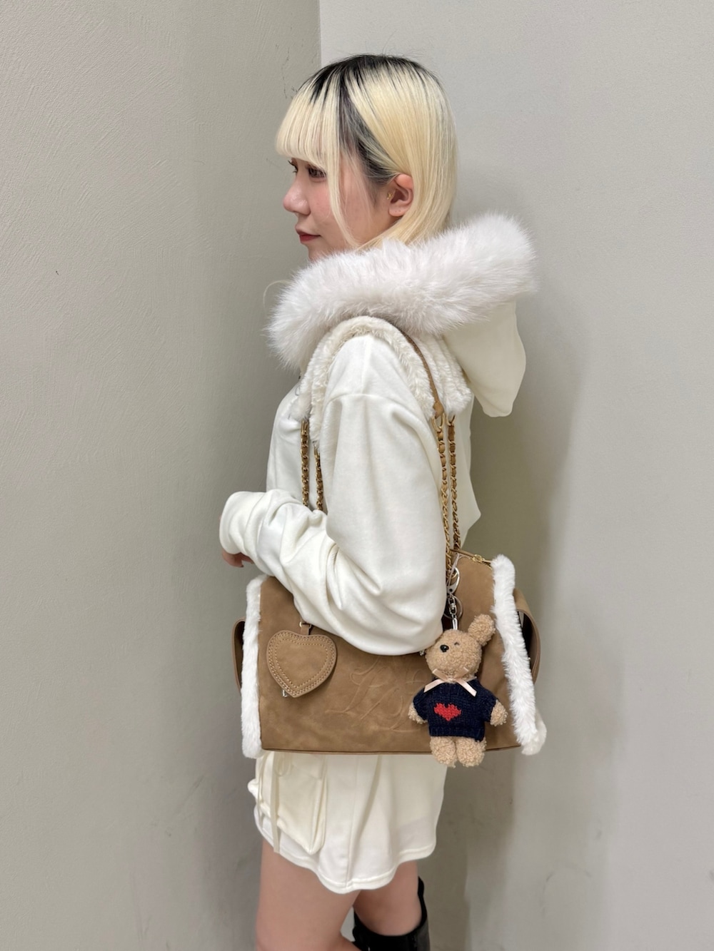 ベージュ系のパーカー、ベージュ系のスカート、イエロー系のボストンバッグを着用したレディースの冬コーディネートの7枚目の写真