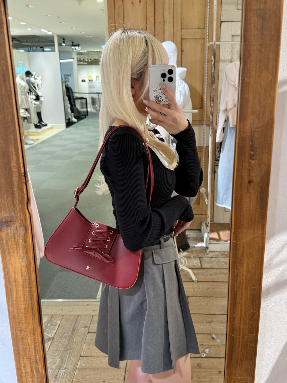 ブラック系のニット/セーター、レッド系のショルダーバッグ、グレー系のスカートを着用したレディースの冬コーディネートの3枚目の写真