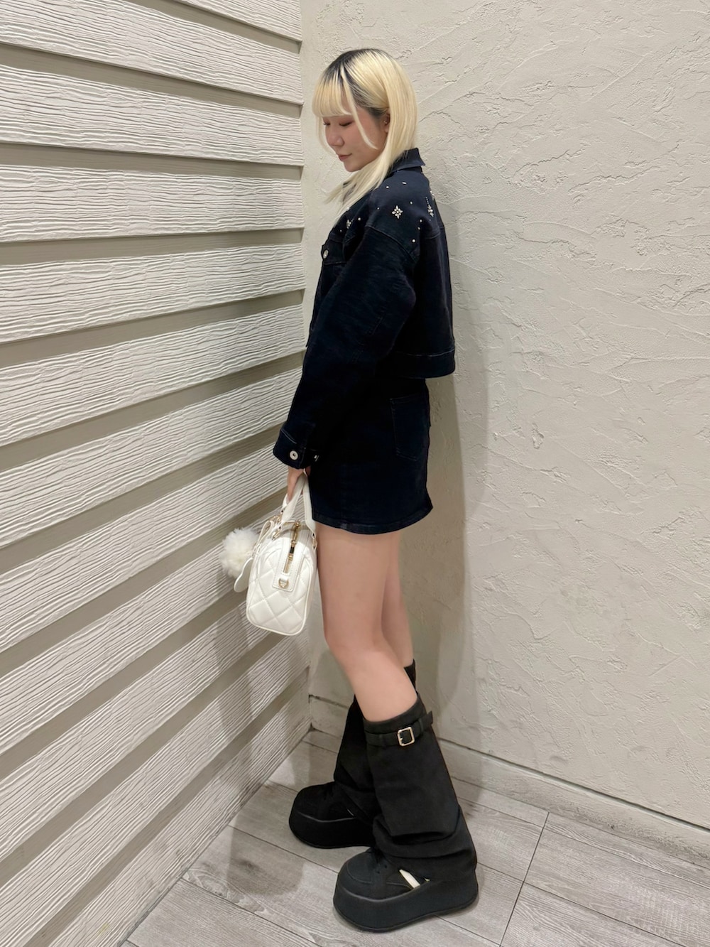 ブルー系のデニムジャケット、ブルー系のデニムスカート、ホワイト系のボストンバッグを着用したレディースの冬コーディネートの2枚目の写真