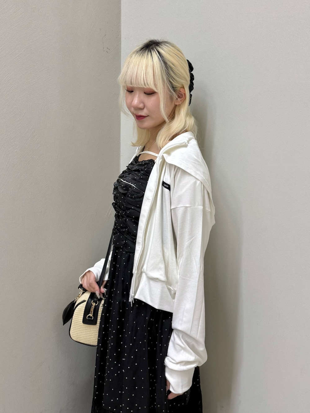 ホワイト系のパーカー、ブラック系のワンピース、ブラック系のショルダーバッグを着用したレディースの夏コーディネートの5枚目の写真