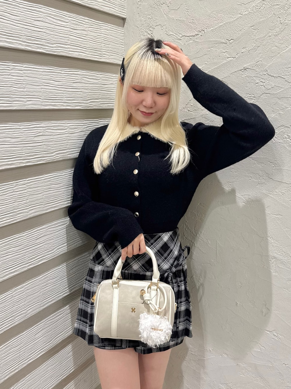 ブラック系のスカート、ホワイト系のボストンバッグ、ホワイト系のブーツを着用したレディースの秋コーディネートの4枚目の写真