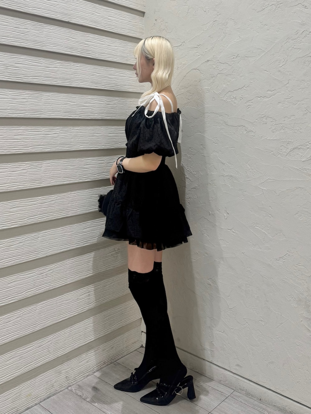 ブラック系のショルダーバッグ、ブラック系のパンプス、ブラック系のワンピースを着用したレディースの春コーディネートの2枚目の写真