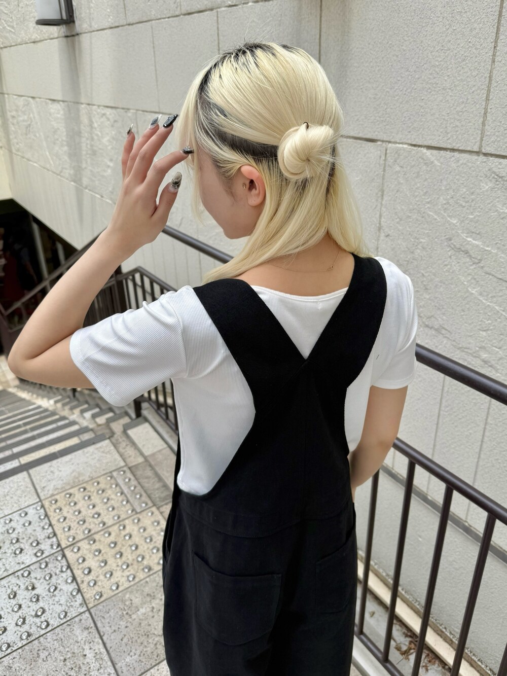 ブラック系のサロペット/オーバーオール、ホワイト系のTシャツ/カットソー、ホワイト系のサンダルを着用したレディースの夏コーディネートの5枚目の写真