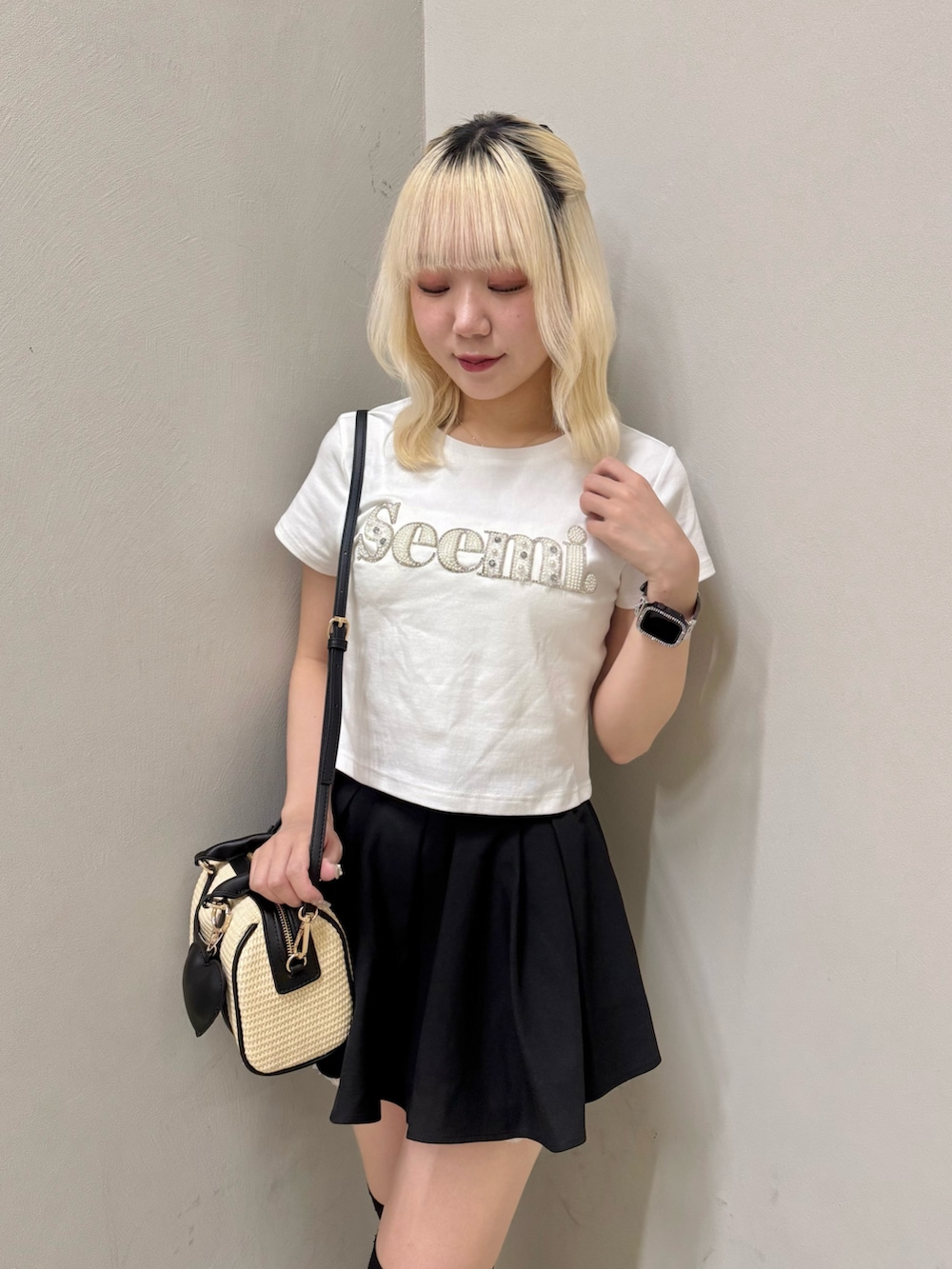 ブラック系のスニーカー、ホワイト系のTシャツ/カットソー、ブラック系のショルダーバッグを着用したレディースの夏コーディネートの4枚目の写真