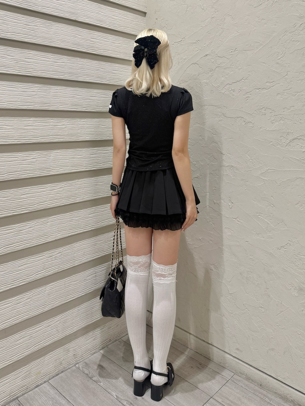 ブラック系のTシャツ/カットソー、ブラック系のショルダーバッグ、ブラック系のパンプスを着用したレディースの春コーディネートの3枚目の写真