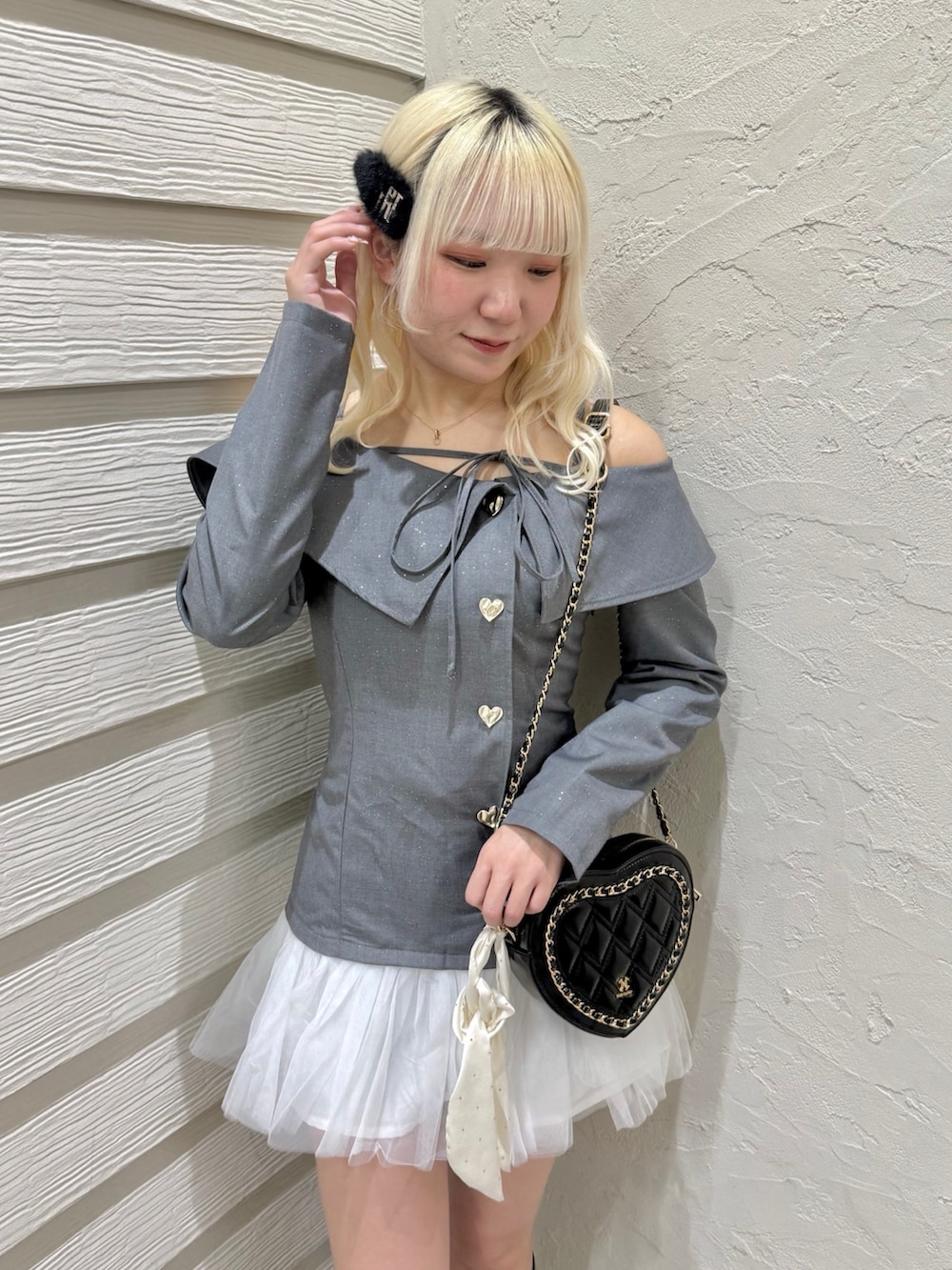 グレー系のワンピース、ブラック系のショルダーバッグ、ブラック系のブーツを着用したレディースの冬コーディネートの4枚目の写真