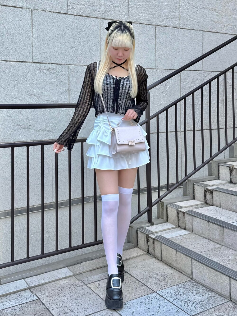 ピンク系のトートバッグ、ピンク系のショルダーバッグ、ブラック系のカーディガン/ボレロを着用したレディースの春コーディネートの3枚目の写真