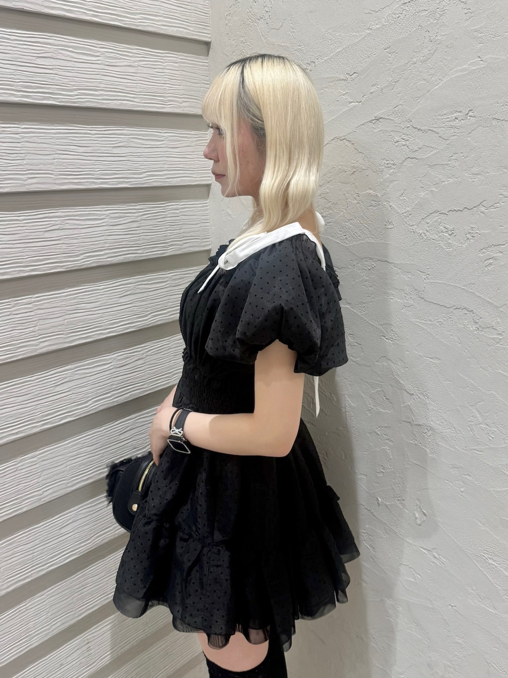 ブラック系のショルダーバッグ、ブラック系のパンプス、ブラック系のワンピースを着用したレディースの春コーディネートの6枚目の写真