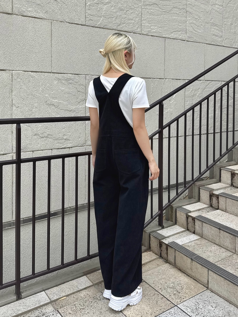ブラック系のサロペット/オーバーオール、ホワイト系のTシャツ/カットソー、ホワイト系のサンダルを着用したレディースの夏コーディネートの3枚目の写真