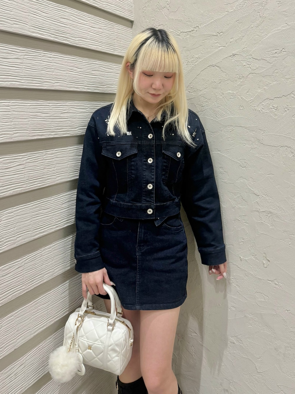 ブルー系のデニムジャケット、ブルー系のデニムスカート、ホワイト系のボストンバッグを着用したレディースの冬コーディネートの4枚目の写真