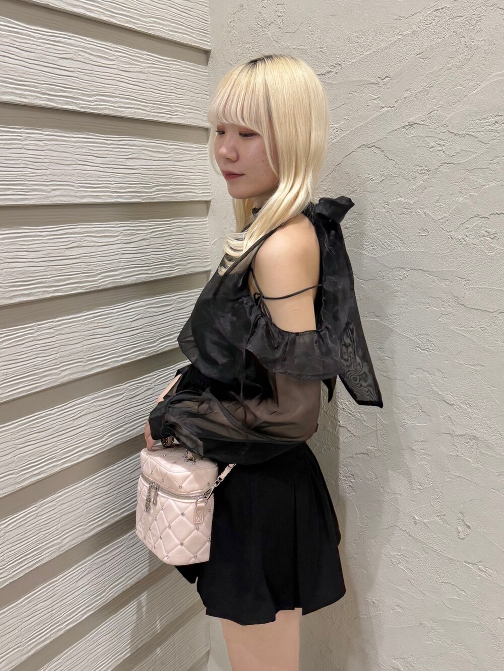 ブラック系のスカート、ブラック系のシャツ/ブラウス、ピンク系のショルダーバッグを着用したレディースの秋コーディネートの5枚目の写真