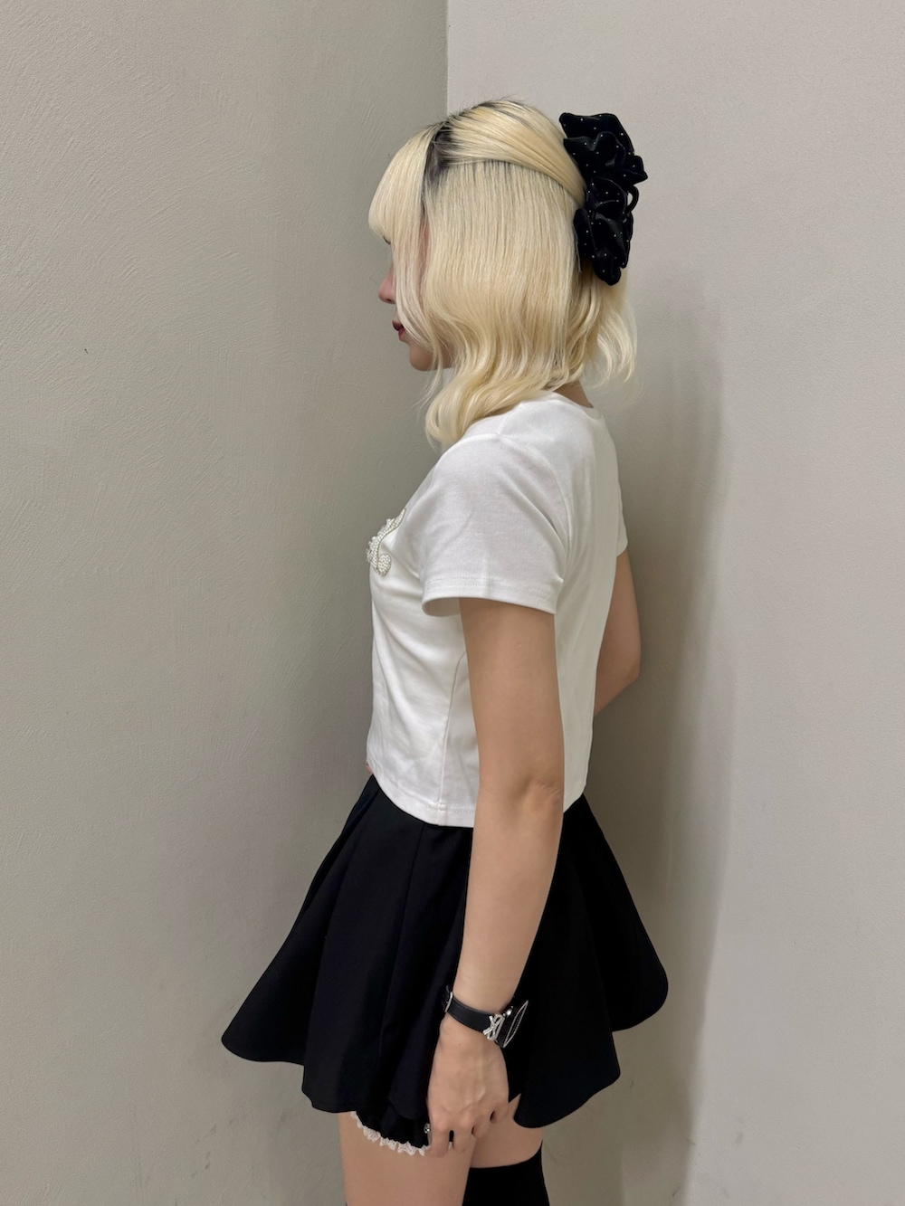 ブラック系のスニーカー、ホワイト系のTシャツ/カットソー、ブラック系のショルダーバッグを着用したレディースの夏コーディネートの5枚目の写真