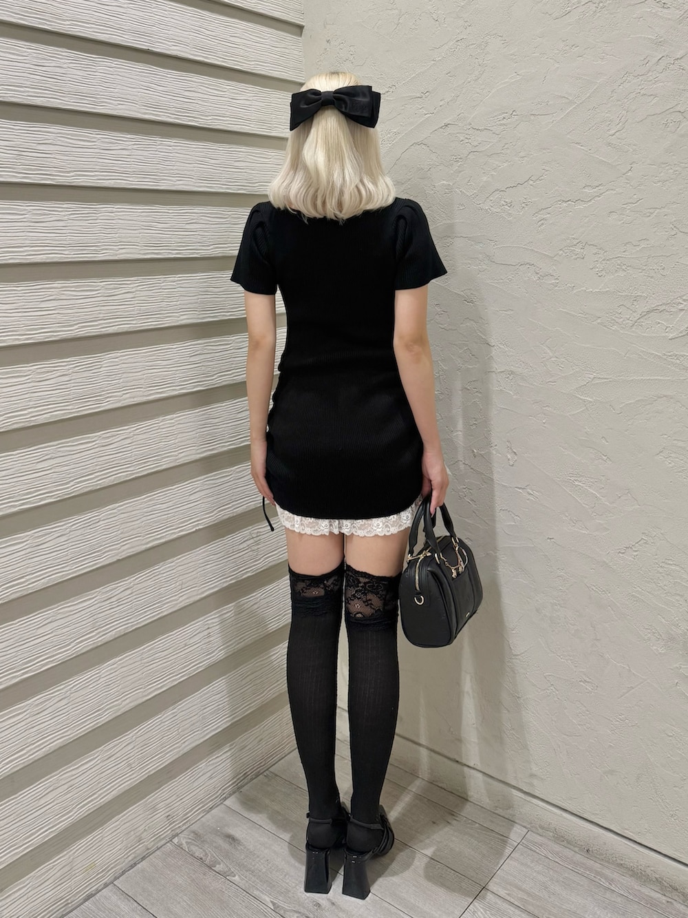 ブラック系のワンピース、ブラック系のショルダーバッグ、ブラック系のパンプスを着用したレディースの夏コーディネートの3枚目の写真