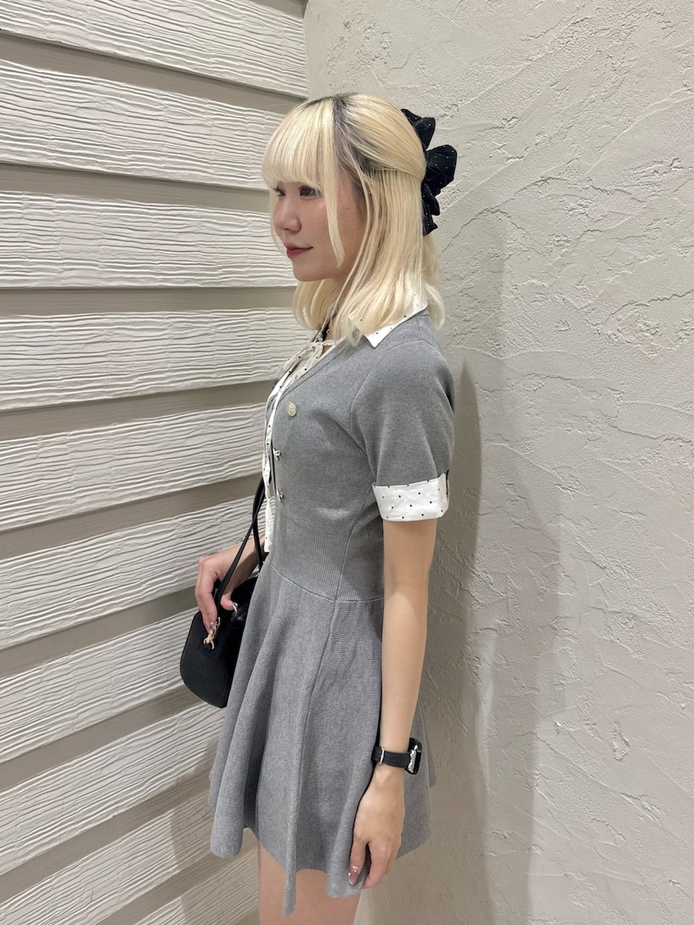 ブラック系のパンプス、ブラック系のショルダーバッグ、グレー系のワンピースを着用したレディースの夏コーディネートの5枚目の写真