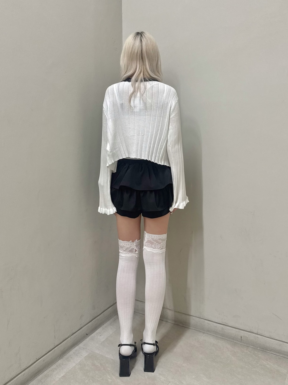 ブラック系のパンプス、ホワイト系のキャミソール、ブラック系のスカートを着用したレディースの春コーディネートの3枚目の写真