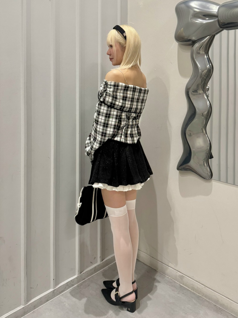 ホワイト系のシャツ/ブラウス、ブラック系のスカート、ブラック系のパンプスを着用したレディースの春コーディネートの2枚目の写真