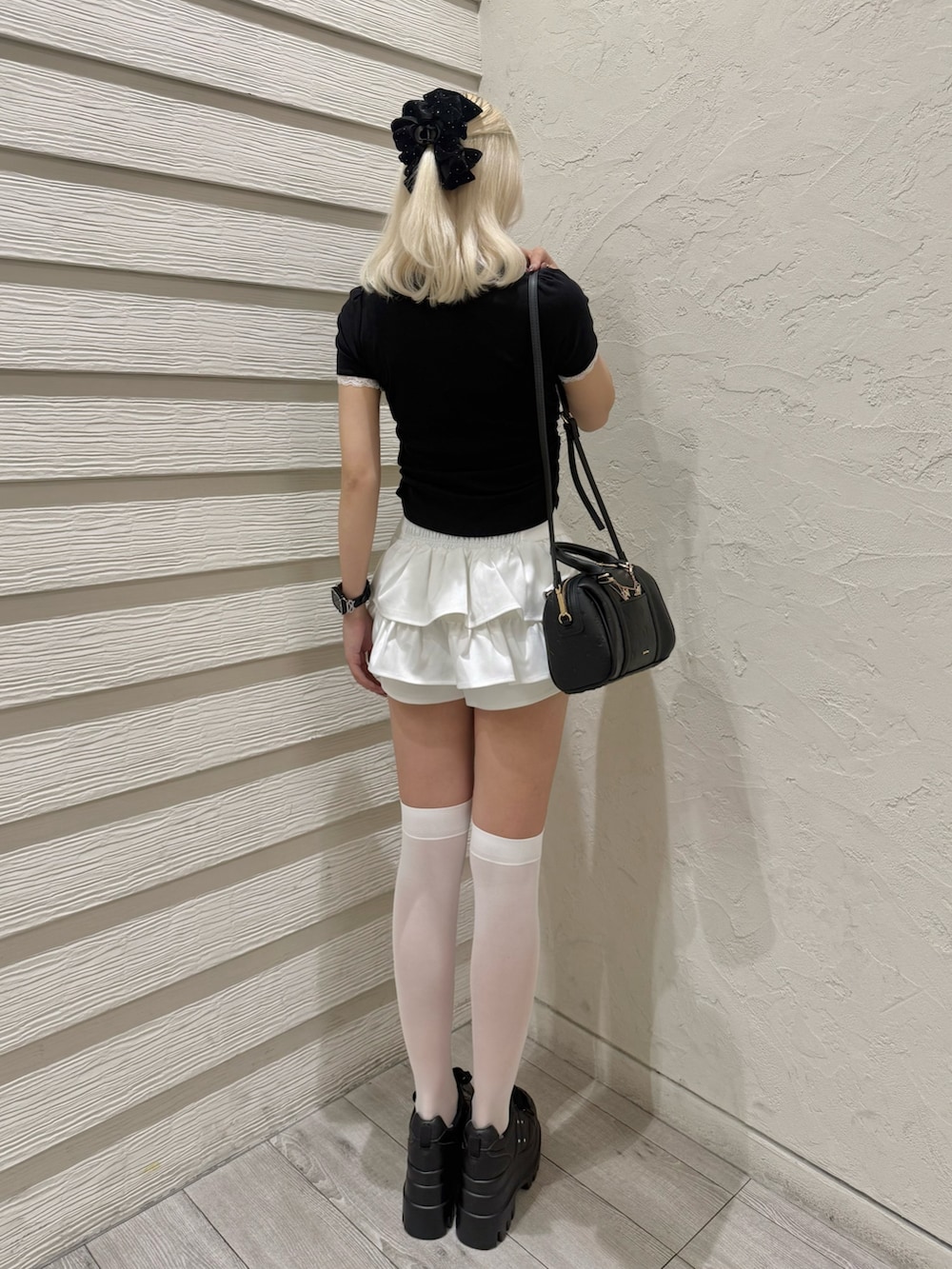 ブラック系のTシャツ/カットソー、ホワイト系のスカート、ブラック系のショルダーバッグを着用したレディースの夏コーディネートの3枚目の写真