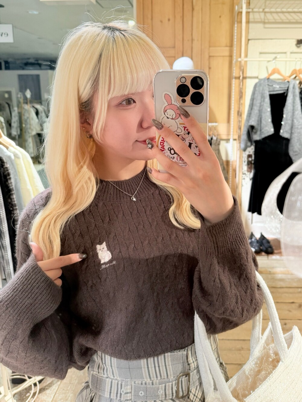 ブラウン系のブーツ、ホワイト系のトートバッグ、その他のスカートを着用したレディースの秋コーディネートの3枚目の写真