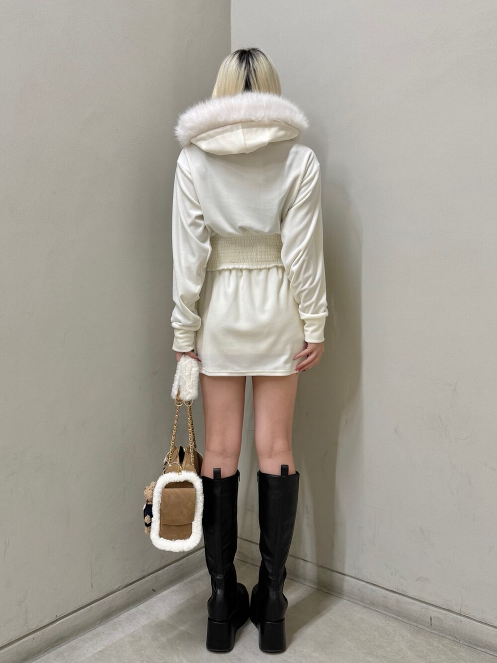 ベージュ系のパーカー、ベージュ系のスカート、イエロー系のボストンバッグを着用したレディースの冬コーディネートの4枚目の写真