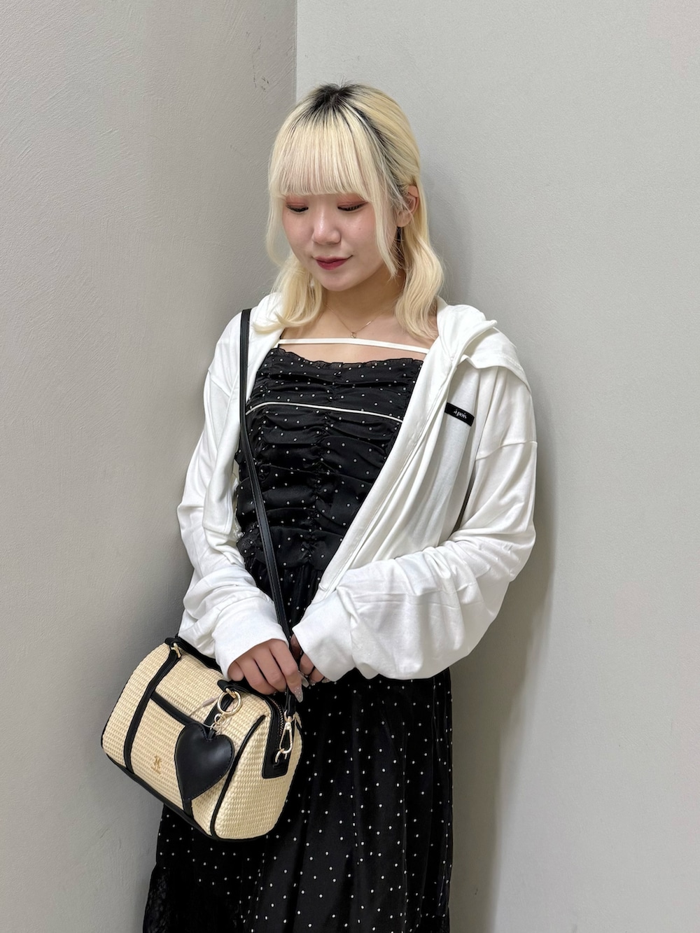 ホワイト系のパーカー、ブラック系のワンピース、ブラック系のショルダーバッグを着用したレディースの夏コーディネートの4枚目の写真