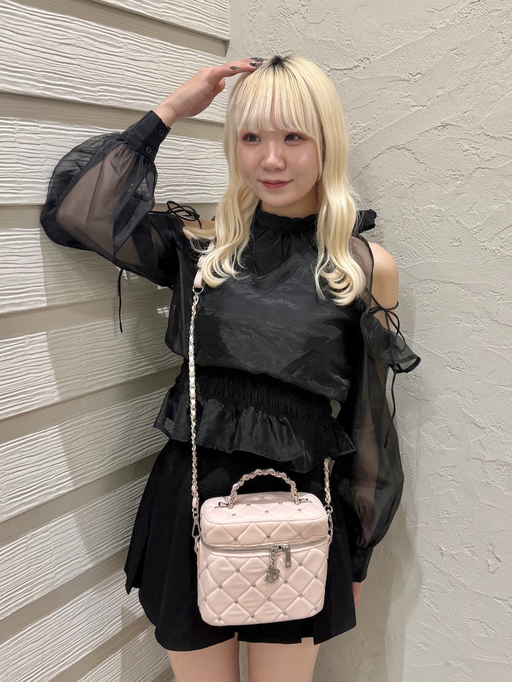 ブラック系のスカート、ブラック系のシャツ/ブラウス、ピンク系のショルダーバッグを着用したレディースの秋コーディネートの4枚目の写真